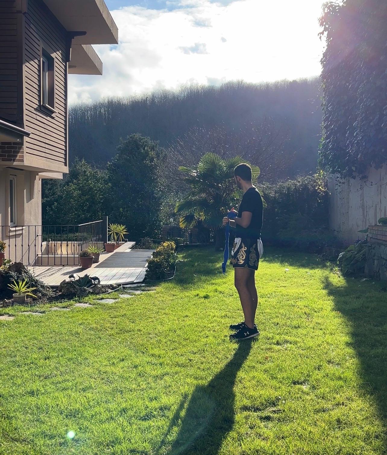 Arda Orak wrapping boxing bandage, house backyard, 2024